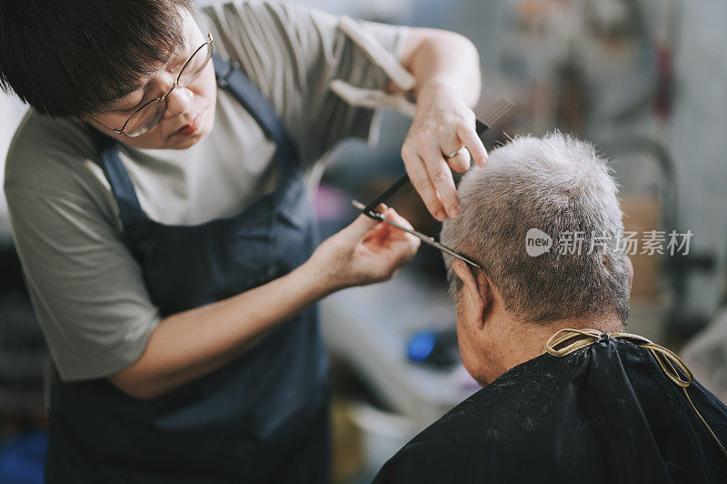 an asian chinese mid adult woman is cutting and trimming hair for her father in the kitchen due to travel ban